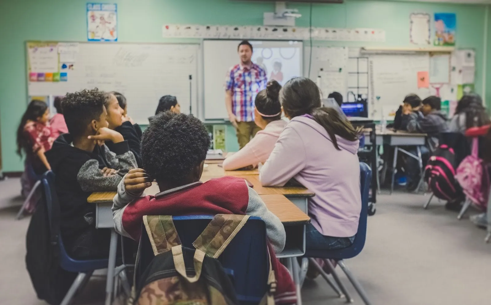 A class listening as their teacher works at the board