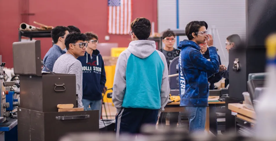 High school students talking together in a school workshop