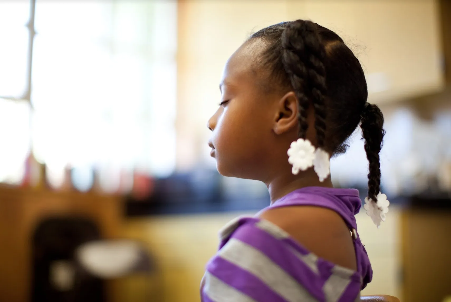 A young student sits with eyes closed during a quiet classroom mindfulness practice