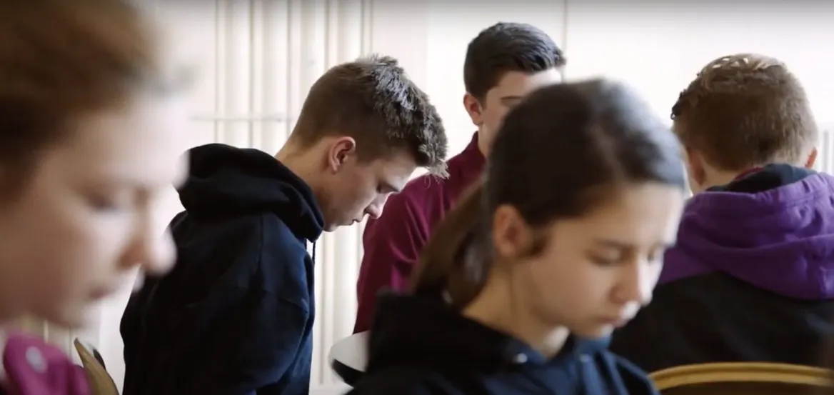 Teenage students sit with heads bowed during a mindfulness practice