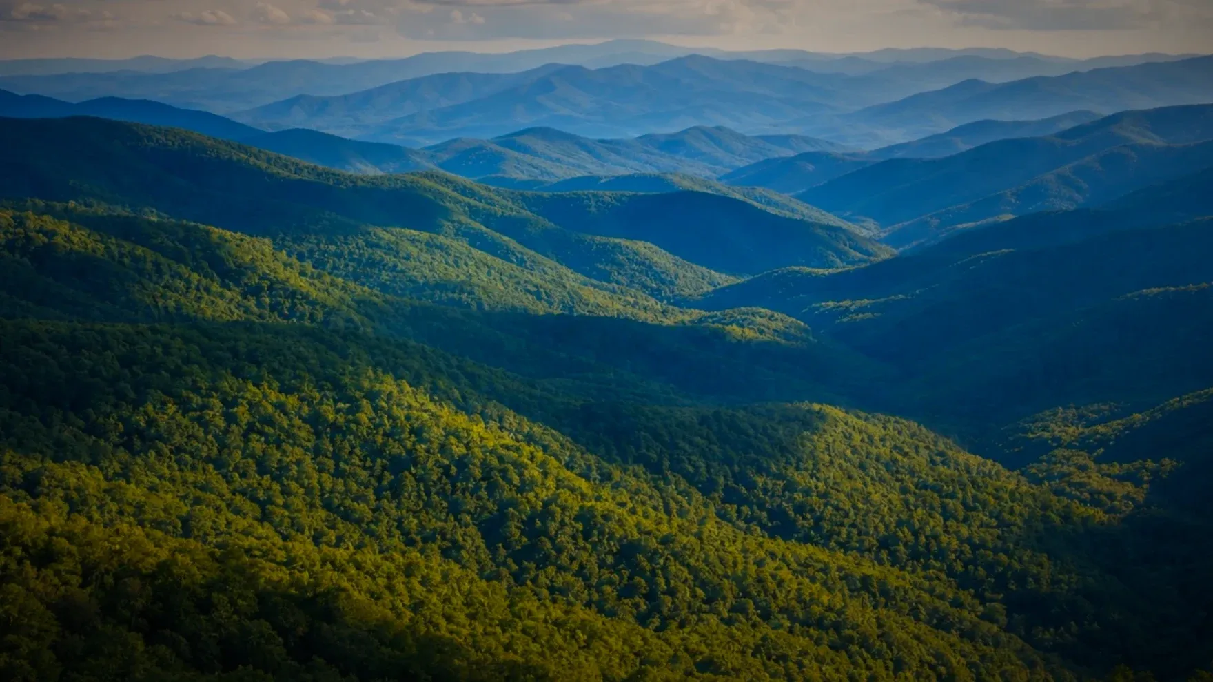 Forested mountain ridges under a cloudy sky, from the Day 13 practice Introduction to Observing Senses