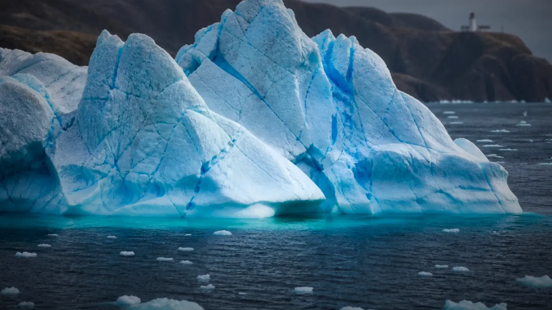 An iceberg in dark water off a rocky coast, from the Day 9 practice Observing Thoughts