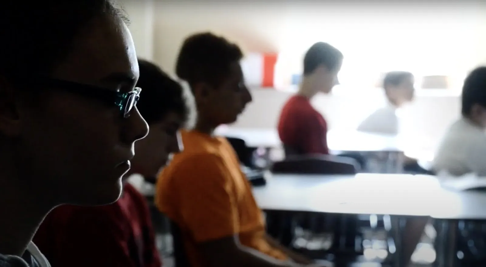 Older students sit in quiet focus during a classroom practice