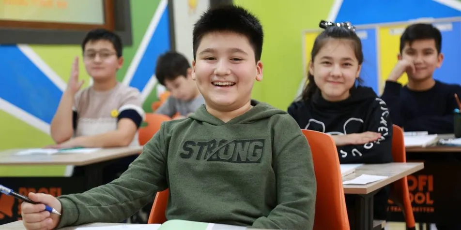Smiling middle school students at their desks in a colorful classroom